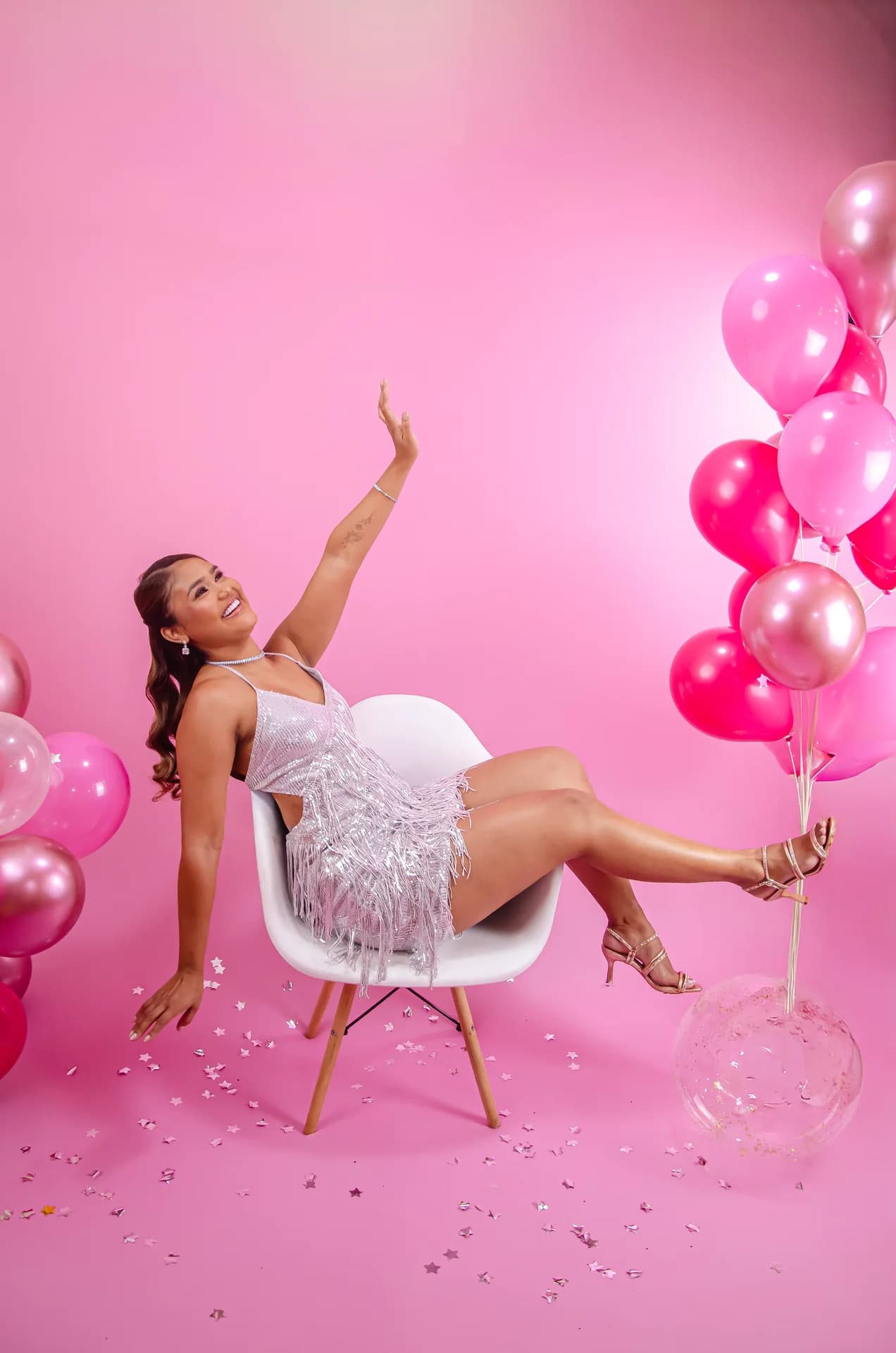 Ensaio feminino com vestido prateado em cenário rosa